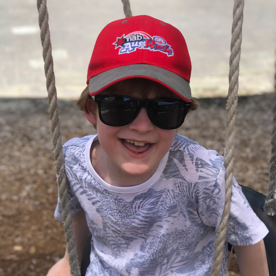 A younger AJ showing his infectious smile while on a swing